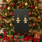 Gingerbread man earrings displayed in front of a decorated Christmas tree and presents.